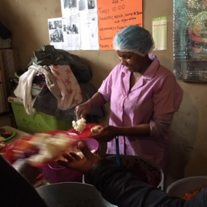 A volunteer at Yiza Ekhaya dishing up food